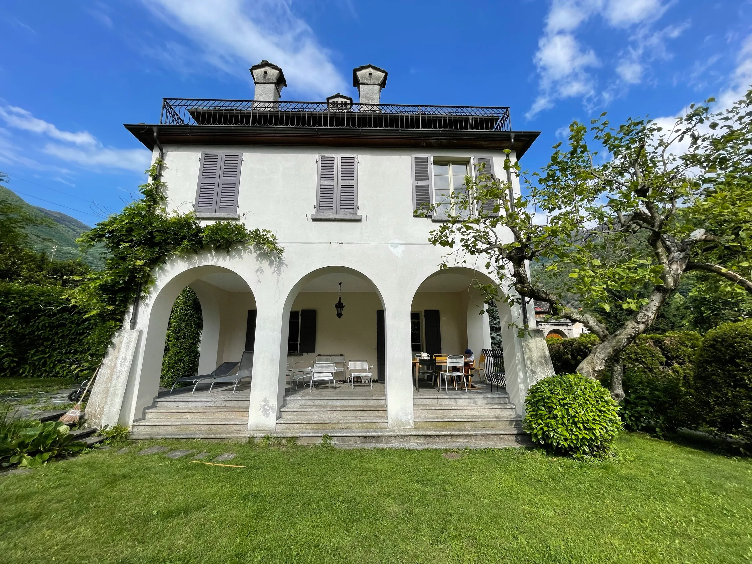 Die Frontansicht von Toveda mit Arkadengang und Garten